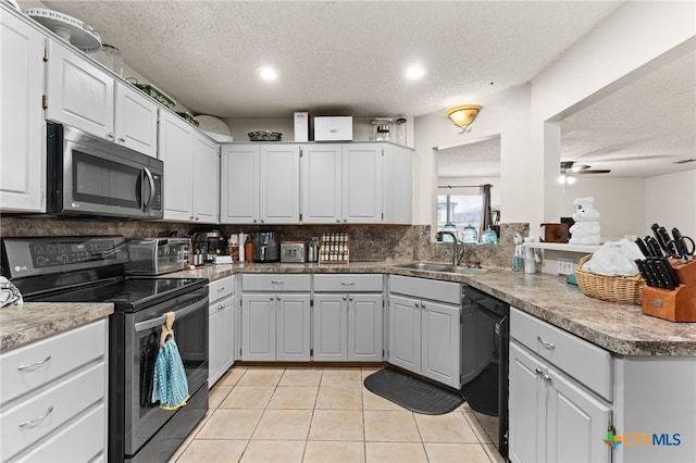 kitchen featuring light tile patterned floors, a sink, electric range oven, black dishwasher, and stainless steel microwave