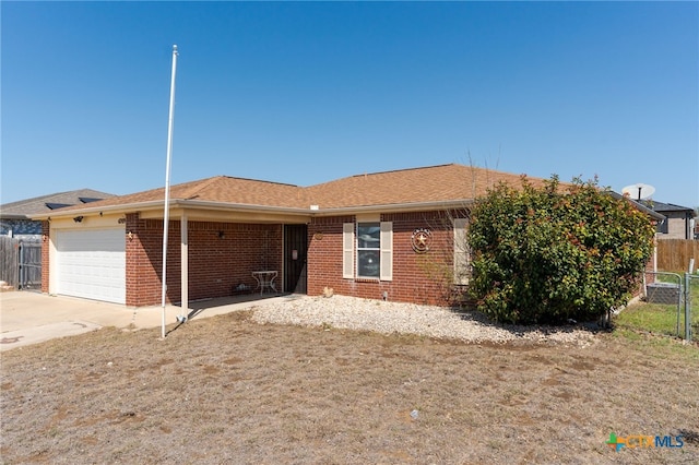 ranch-style home with an attached garage, fence, brick siding, and driveway