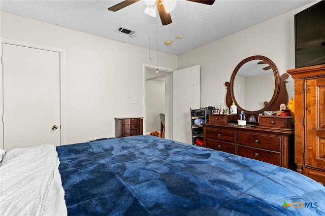 bedroom with visible vents, a textured ceiling, and ceiling fan