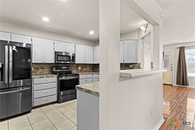 4209 Stallion Dr, Killeen, TX 76549 - kitchen with appliances with stainless steel finishes, tasteful backsplash, white cabinets, recessed lighting, and light countertops