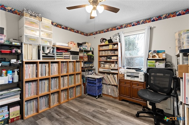 home office with a textured ceiling, a ceiling fan, and wood finished floors