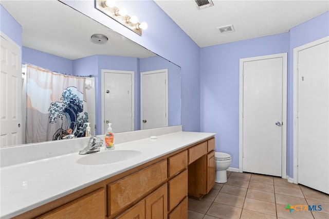 bathroom featuring tile patterned floors, visible vents, toilet, baseboards, and vanity