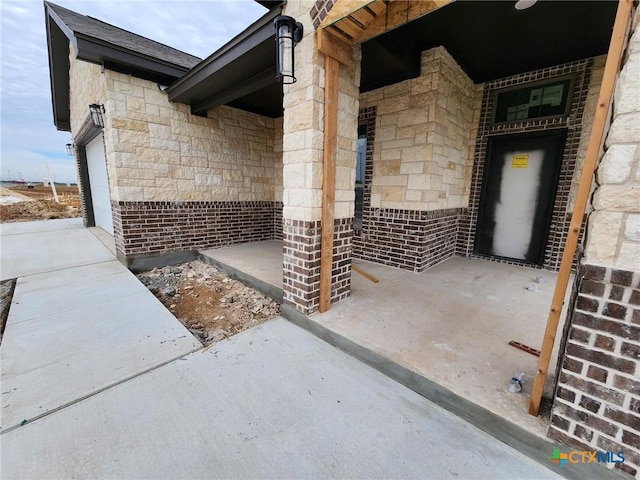 view of patio / terrace featuring elevator and a garage