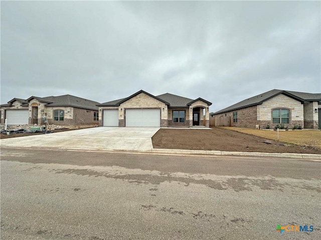 ranch-style home with a garage, driveway, brick siding, and fence