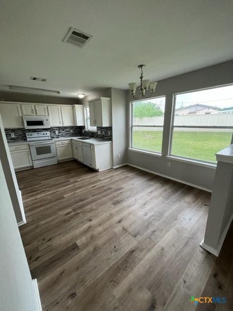 kitchen with dark wood-style flooring, visible vents, an inviting chandelier, white appliances, and white cabinetry