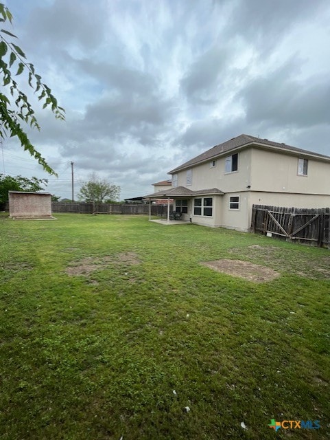 view of yard with a fenced backyard, a storage unit, and an outdoor structure