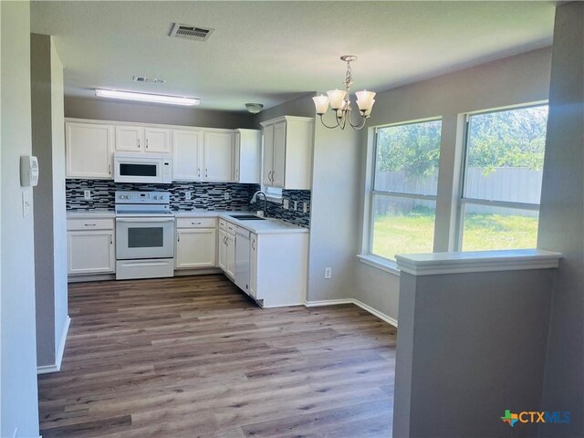 5408 Donegal Bay Ct, Killeen, TX 76549 - kitchen with white appliances, a chandelier, white cabinetry, and decorative backsplash