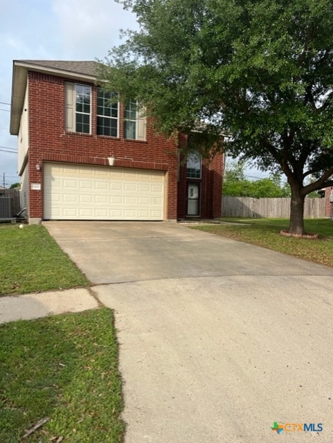 view of front of house featuring brick siding, fence, and concrete driveway