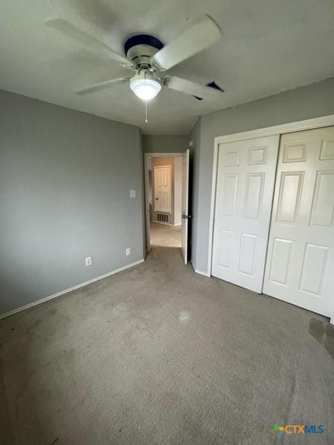 unfurnished bedroom with ceiling fan, visible vents, baseboards, a closet, and carpet
