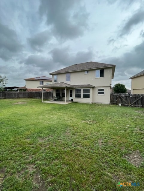 rear view of house with a patio, a fenced backyard, and a yard