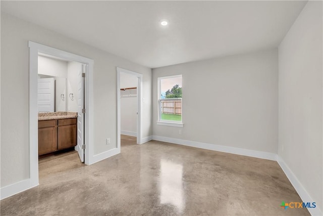 2402 Healy Dr, Temple, TX 76502 - unfurnished bedroom with concrete flooring, a walk in closet, baseboards, a closet, and ensuite bath