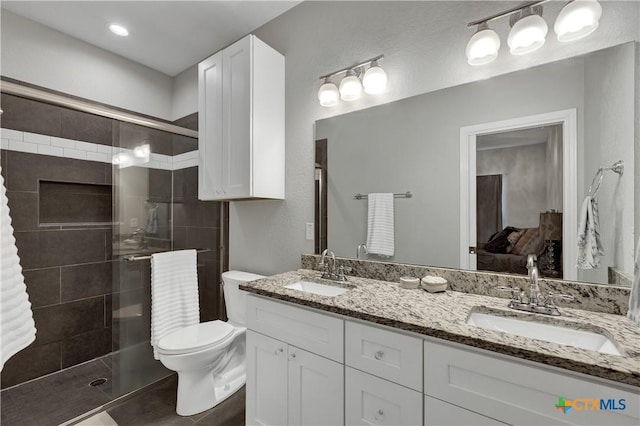 bathroom with tile patterned flooring, vanity, toilet, and a shower with shower door