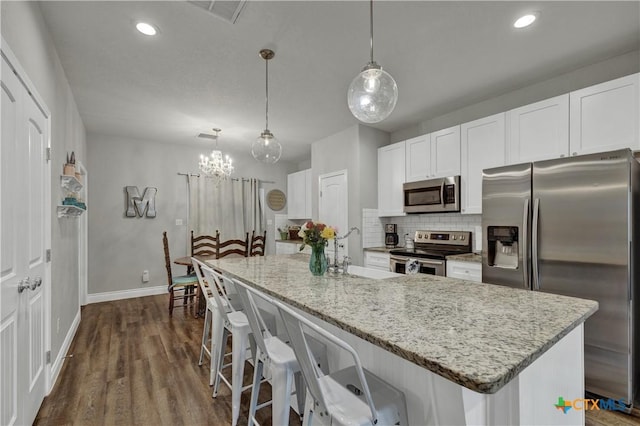 kitchen with white cabinets, pendant lighting, sink, and stainless steel appliances