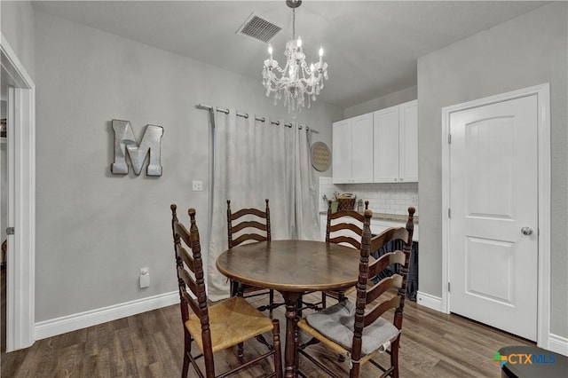 dining room with a chandelier and dark wood-type flooring