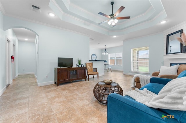 2655 Belle Hubbard Trl, Belton, TX 76513 - living area featuring crown molding, arched walkways, ceiling fan, a fireplace, and a raised ceiling