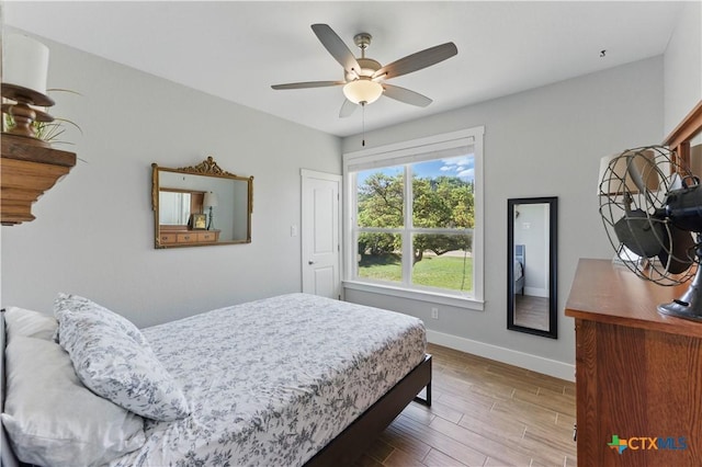 bedroom with baseboards, ceiling fan, and wood finished floors