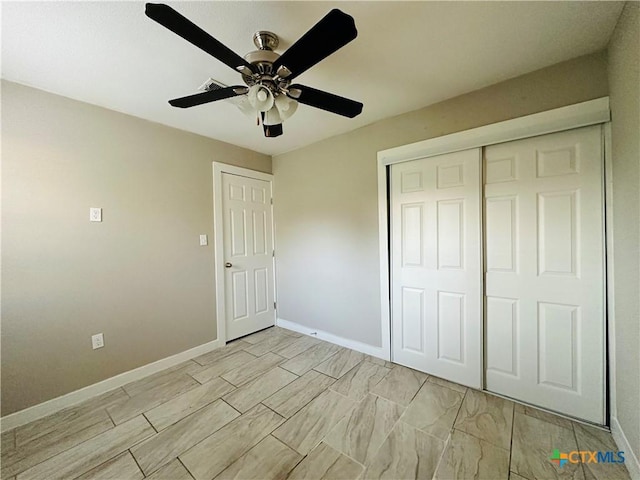 unfurnished bedroom with ceiling fan and a closet