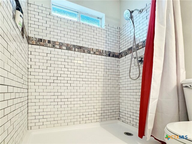 bathroom featuring toilet and a shower with shower curtain