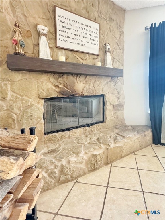 room details with a stone fireplace and tile patterned floors