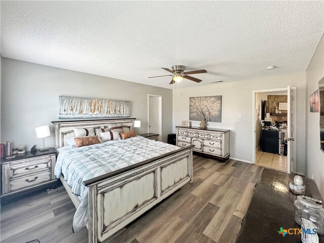 bedroom with ceiling fan, wood-type flooring, and a textured ceiling