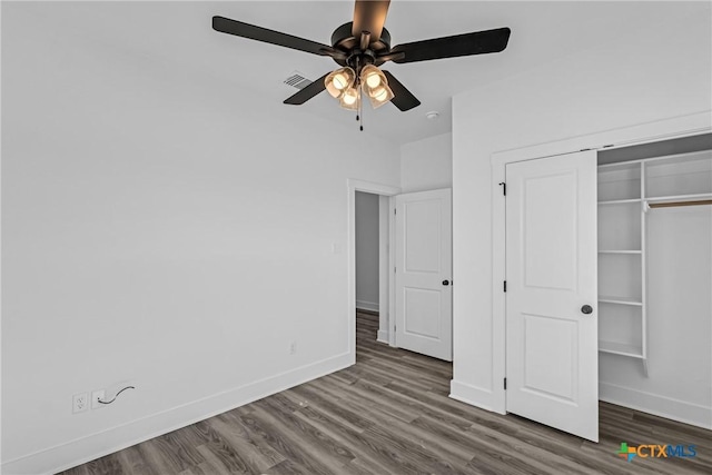 unfurnished bedroom with ceiling fan, dark hardwood / wood-style floors, and a closet