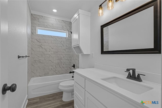 full bathroom featuring wood-type flooring, vanity, toilet, and tiled shower / bath