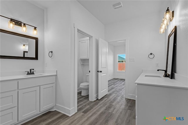 bathroom with hardwood / wood-style floors, vanity, and toilet