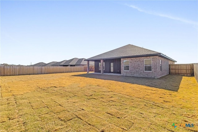 back of house with a yard and a patio