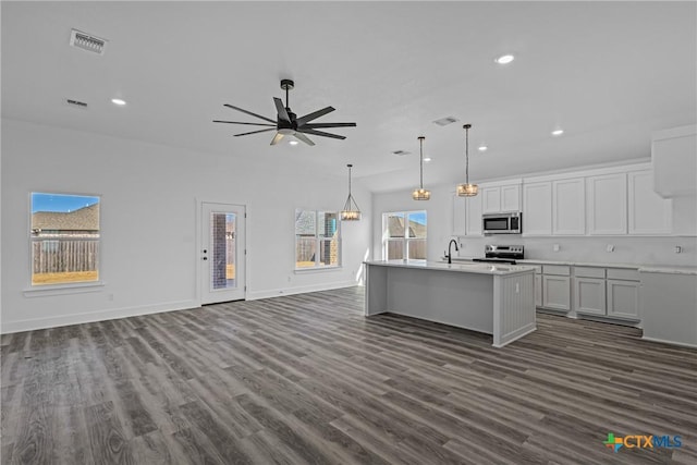 kitchen featuring a center island with sink, dark hardwood / wood-style floors, ceiling fan, appliances with stainless steel finishes, and white cabinetry