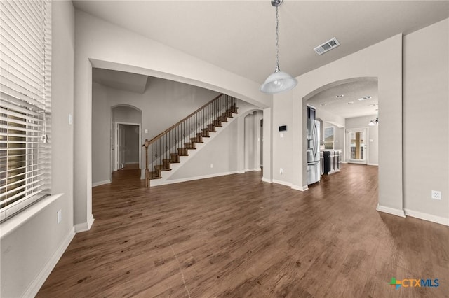 4703 Prewitt Ranch Rd, Killeen, TX 76549 - unfurnished living room featuring arched walkways, dark wood finished floors, stairway, and baseboards