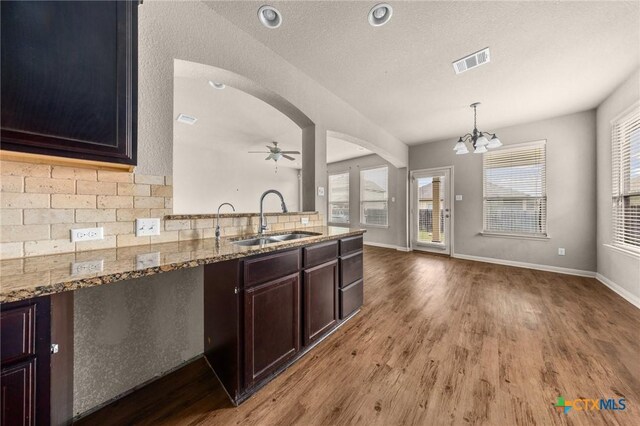 4703 Prewitt Ranch Rd, Killeen, TX 76549 - kitchen featuring a sink, wood finished floors, decorative backsplash, a chandelier, and light stone countertops
