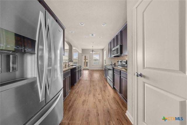 4703 Prewitt Ranch Rd, Killeen, TX 76549 - kitchen with appliances with stainless steel finishes, light wood-type flooring, decorative backsplash, light stone countertops, and recessed lighting