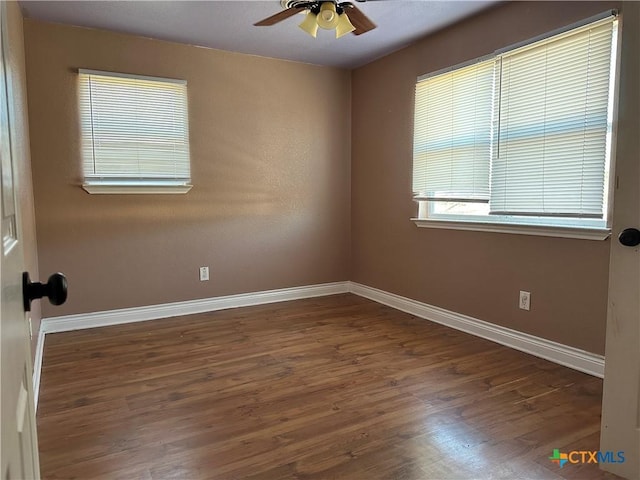 empty room with dark hardwood / wood-style flooring and ceiling fan