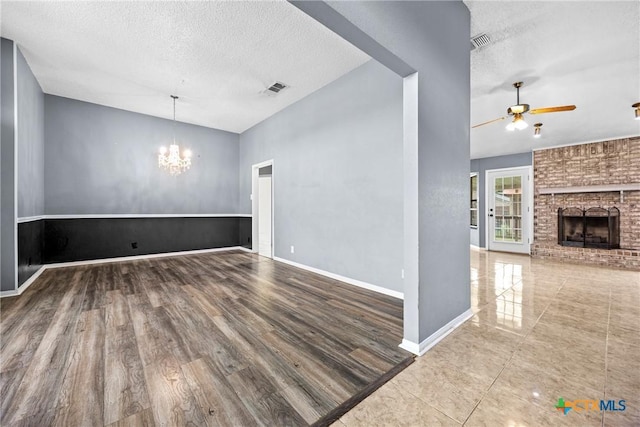 4818 Bramblewood Dr, Killeen, TX 76542 - unfurnished living room with a textured ceiling, lofted ceiling, a chandelier, a ceiling fan, and a fireplace