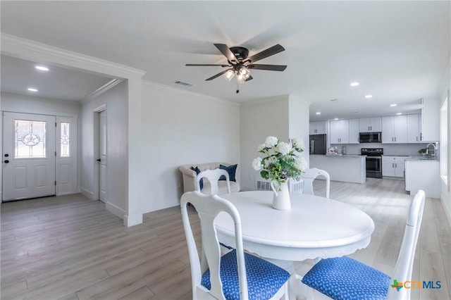 dining area featuring light wood-style flooring, recessed lighting, a ceiling fan, visible vents, and ornamental molding