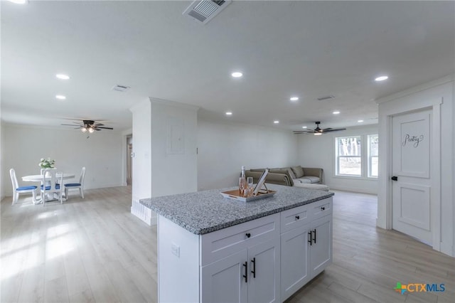 kitchen featuring recessed lighting, a kitchen island, visible vents, light wood-style floors, and open floor plan