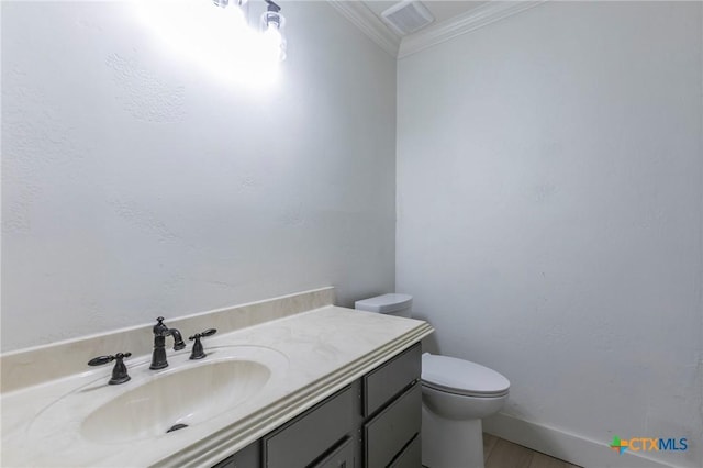 bathroom featuring baseboards, visible vents, toilet, crown molding, and vanity