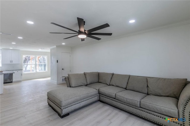 living room with light wood-style floors, ornamental molding, and recessed lighting