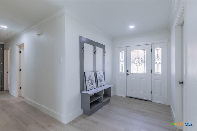 foyer with light wood-style floors, crown molding, and baseboards