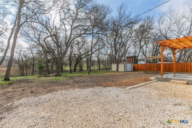 view of yard with an outbuilding, a shed, fence, and a pergola