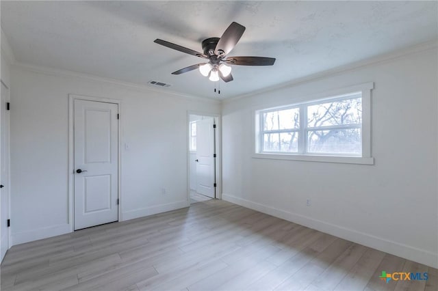 unfurnished bedroom featuring visible vents, light wood-style flooring, ornamental molding, a ceiling fan, and baseboards