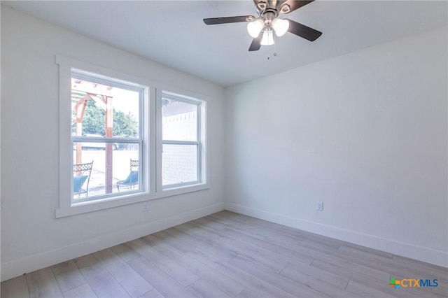 empty room with light wood-style floors, ceiling fan, and baseboards