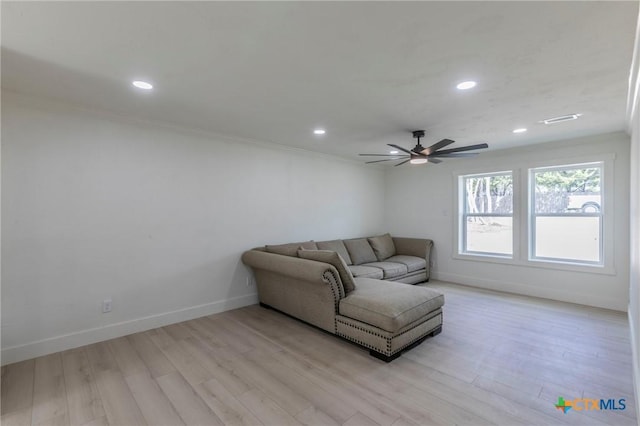 living room featuring crown molding, light hardwood / wood-style floors, and ceiling fan