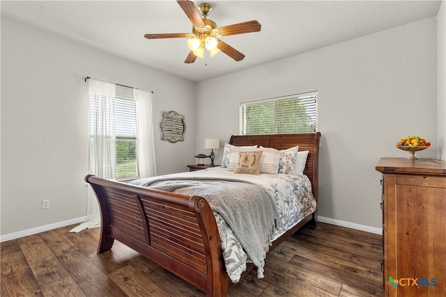 bedroom with multiple windows, dark wood-type flooring, and ceiling fan