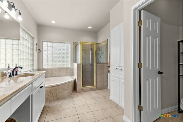 bathroom featuring shower with separate bathtub, vanity, and tile patterned floors