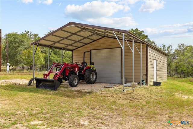 view of outbuilding featuring a garage, a yard, and a carport