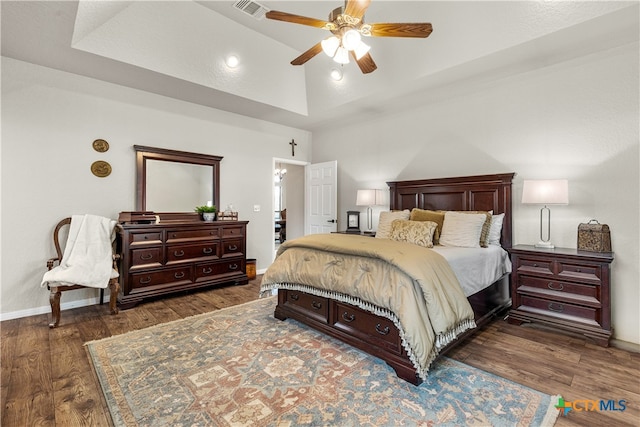 bedroom with dark wood-type flooring, vaulted ceiling, and ceiling fan