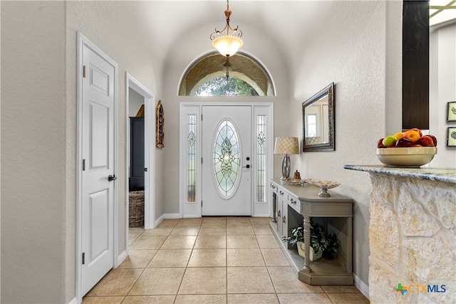 tiled foyer featuring vaulted ceiling