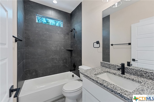 full bathroom featuring toilet, tiled shower / bath combo, and vanity