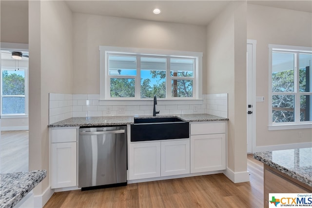 kitchen with a healthy amount of sunlight, white cabinetry, stainless steel dishwasher, and sink